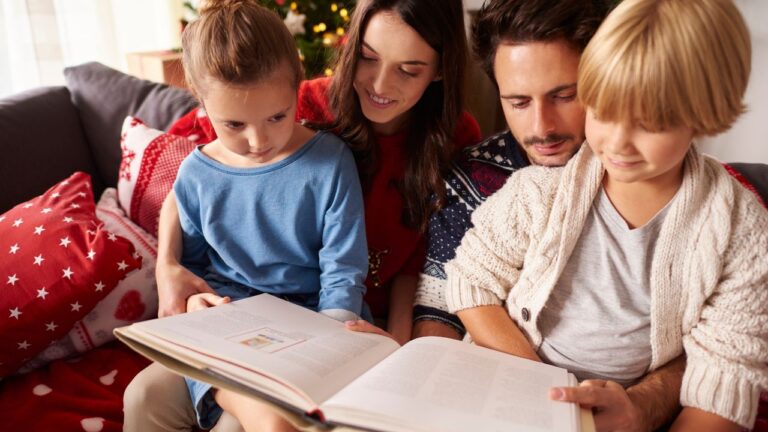 Familia leyendo un libro con niños en el sofá