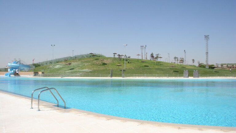Piscina de Parla con agua salada y tobogán azul.