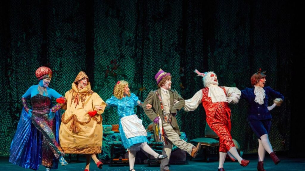 Alicia y los personajes del País de las Maravillas bailan sobre un decorado de fantasía verde en el Teatro Lara.